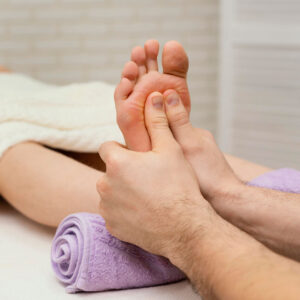 Two hands holding a persons foot.