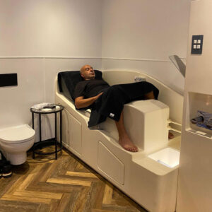 A man is sat on the Angel of Water Colonic Irrigation Machinery at the Angel Wellness Retreat in Essex.