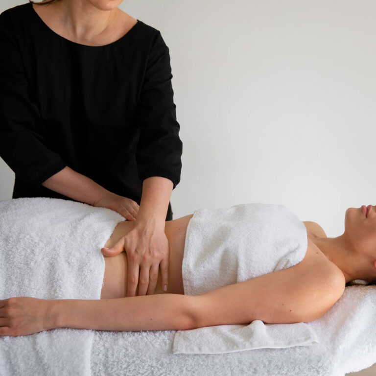A woman is receiving a massage from another woman.