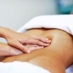 Colon stimulation massage on a woman's stomach.