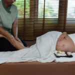 A pregnant woman is receiving a lymphatic drainage massage.