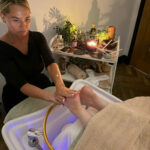A woman is receiving a Japanese Waterfall Heel & Foot Spa Renewal treatment.